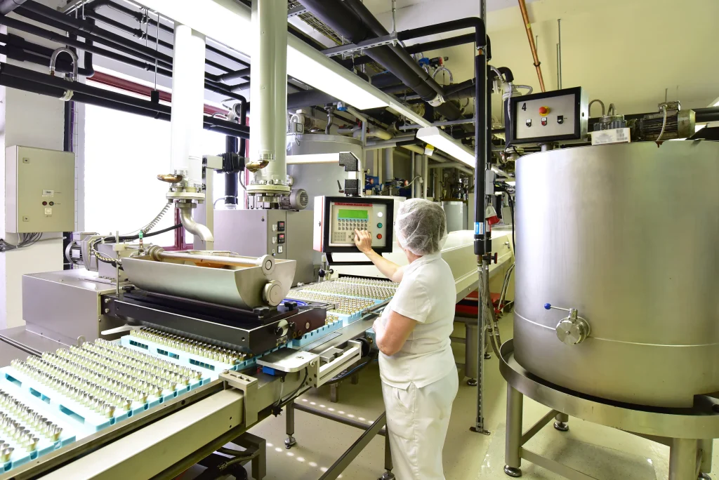 Food Production hall, you see the production line a woman standing over at the machine